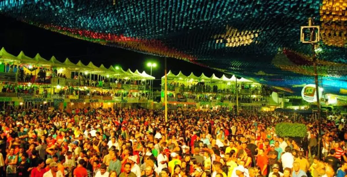 Festa junina na Paraíba com público celebrando e dançando ao som de forró sob iluminação festiva.