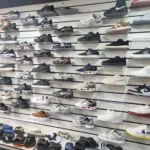 Grande quantidade de roupas, tênis e bonés falsificados apreendidos em operação policial.