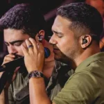 Henrique e Juliano se apresentando no palco do São João de Campina Grande à noite, com luzes coloridas e multidão