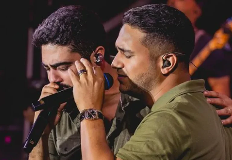 Henrique e Juliano se apresentando no palco do São João de Campina Grande à noite, com luzes coloridas e multidão