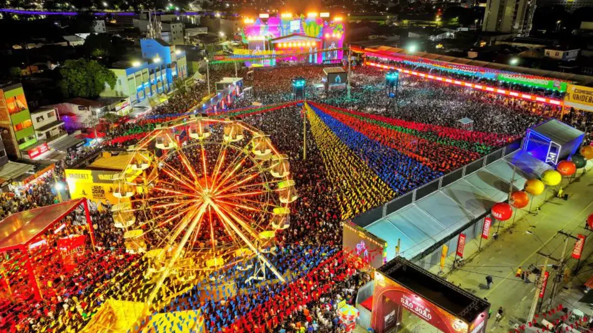 Multidão celebrando o São João de Campina Grande no Parque do Povo, com palco e decorações coloridas