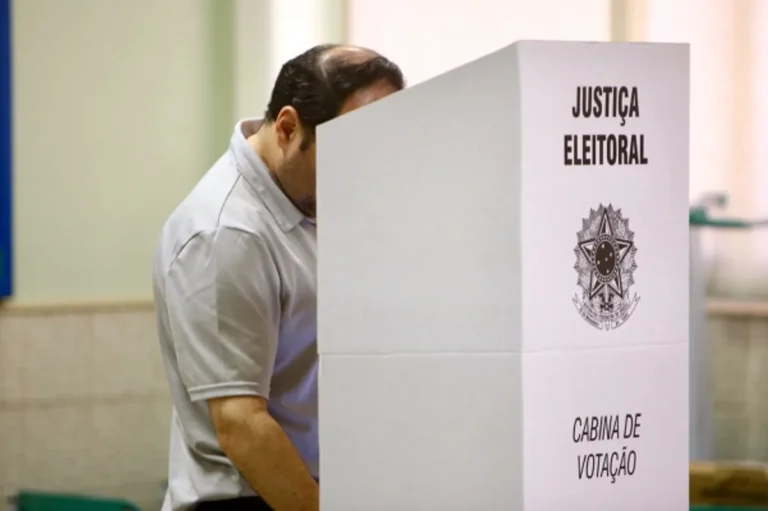 Eleitores na fila para votar em uma seção eleitoral em João Pessoa, Paraíba.
