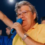 João Azevêdo sorri em evento político na Paraíba, liderando pesquisa.