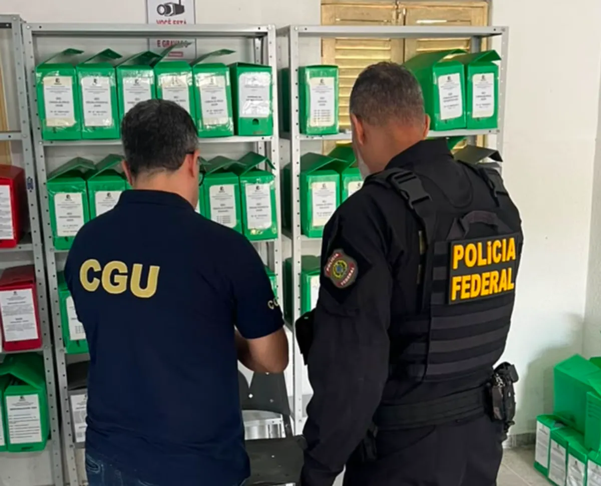 Agentes da Polícia Federal realizam busca e apreensão em escritório durante operação contra fraudes em contratos de obras públicas.