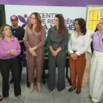 Fachada e equipe do Centro de Referência da Mulher em João Pessoa durante evento comemorativo.