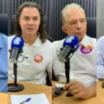 Urna eletrônica com bandeira da Paraíba ao fundo