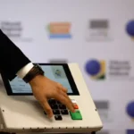 Técnicos do TRE-PB realizando a carga e preparação de urnas eletrônicas para as eleições.