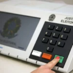Eleitor utilizando urna eletrônica em seção eleitoral durante as eleições de 2026