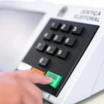 Cidadão utilizando o aplicativo e-Título em celular para consultar local de votação